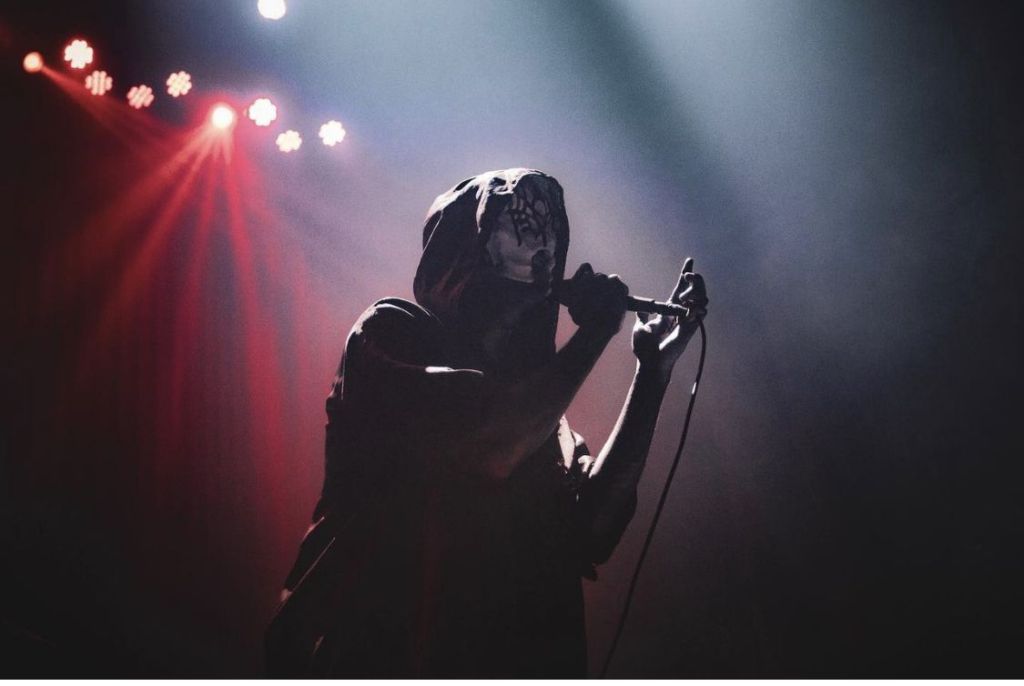 ballades sleep token - Vessel chantant sur scène avec un ancien masque
